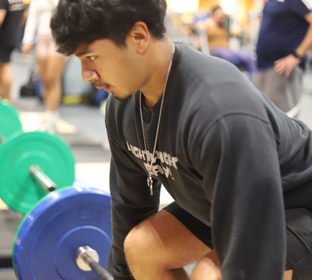 Male student at the School of Personal Training preparing for a deadlift with barbell and weights, showcasing practical strength training and weightlifting techniques taught in our program.