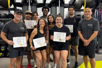 WhatsApp Image 2026-06-07 at 8.44.17 PM (1) A group of successful graduates holding up their certificates from a comprehensive personal trainer certification course.