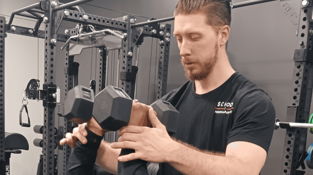 Certified personal trainer student guiding a client through a dumbbell chest press, showcasing hands-on coaching skills and proper form instruction learned in our fitness certification program.